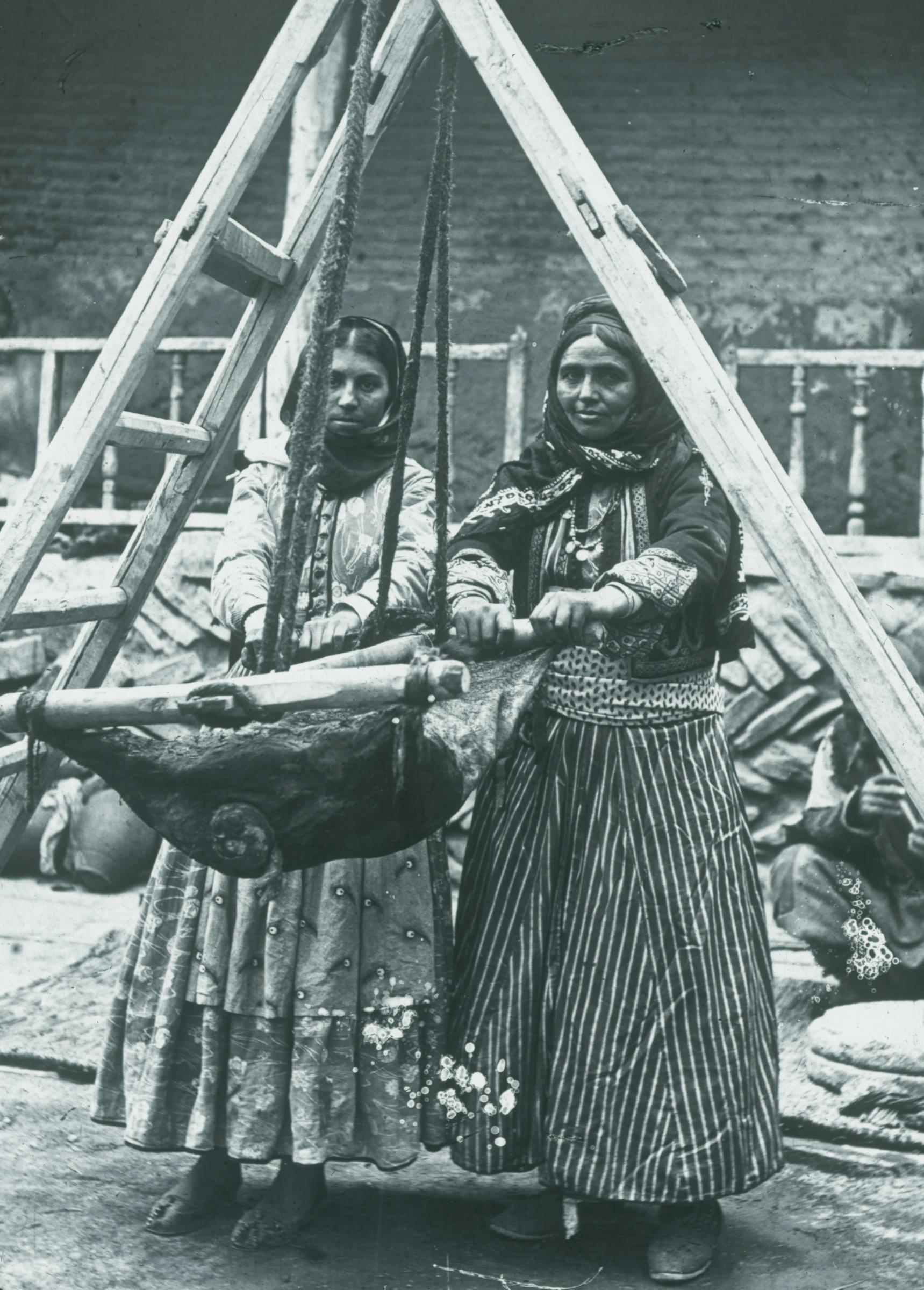 Nestorian (Assyrian) women churning butter in a goatskin