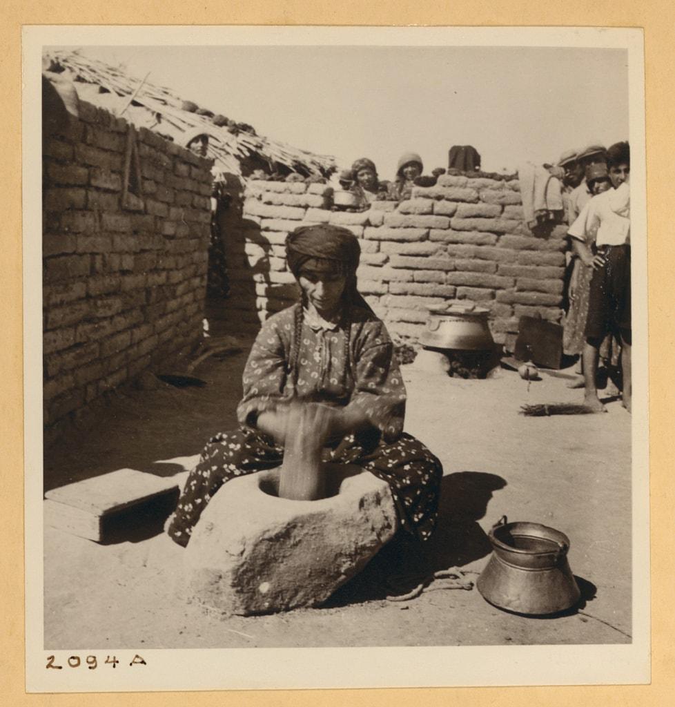 Assyrian woman pounding burghul at Tel Tamer, 1938