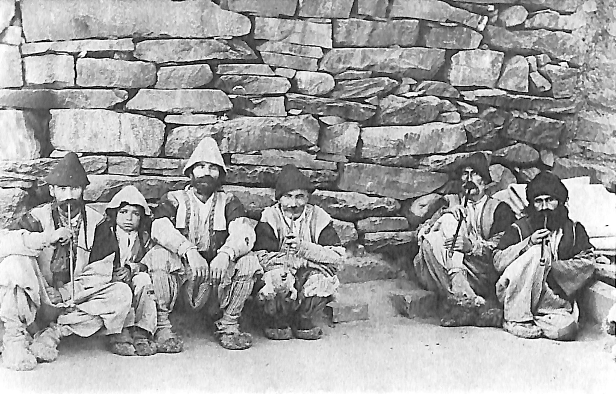 Men of Lower Tyari seated before a stone wall, 1912