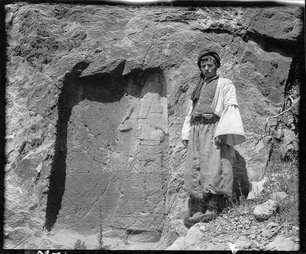 Shim'un, brother of Kasha Mattai, beside an Assyrian rock relief