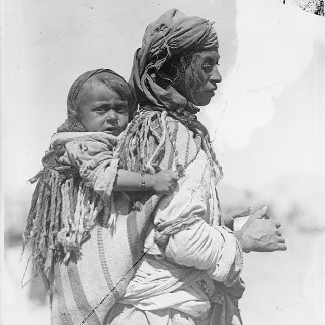 Jilu Assyrian mother carrying her child on her back